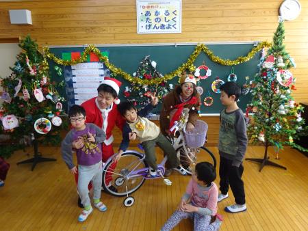 サンタさんから自転車をもらって喜ぶ児童