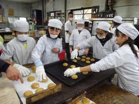 出来上がった饅頭を取り出す児童