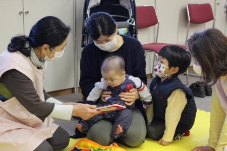 兄と一緒に読み聞かせを聞く赤ちゃん