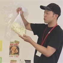 講師が踏む前のうどん生地を紹介する様子