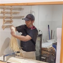 切った麺を持ち上げる講師