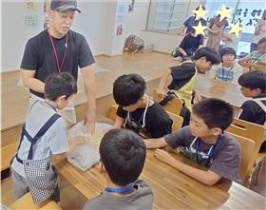 子どもたちが寝かせた生地を触る様子