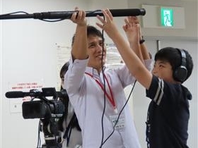 講師がガンマイクの持ち方を参加者へ教える様子