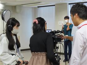 参加者がカメラの操作方法を講師に習う様子