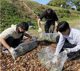 落ち葉を広げる高校生