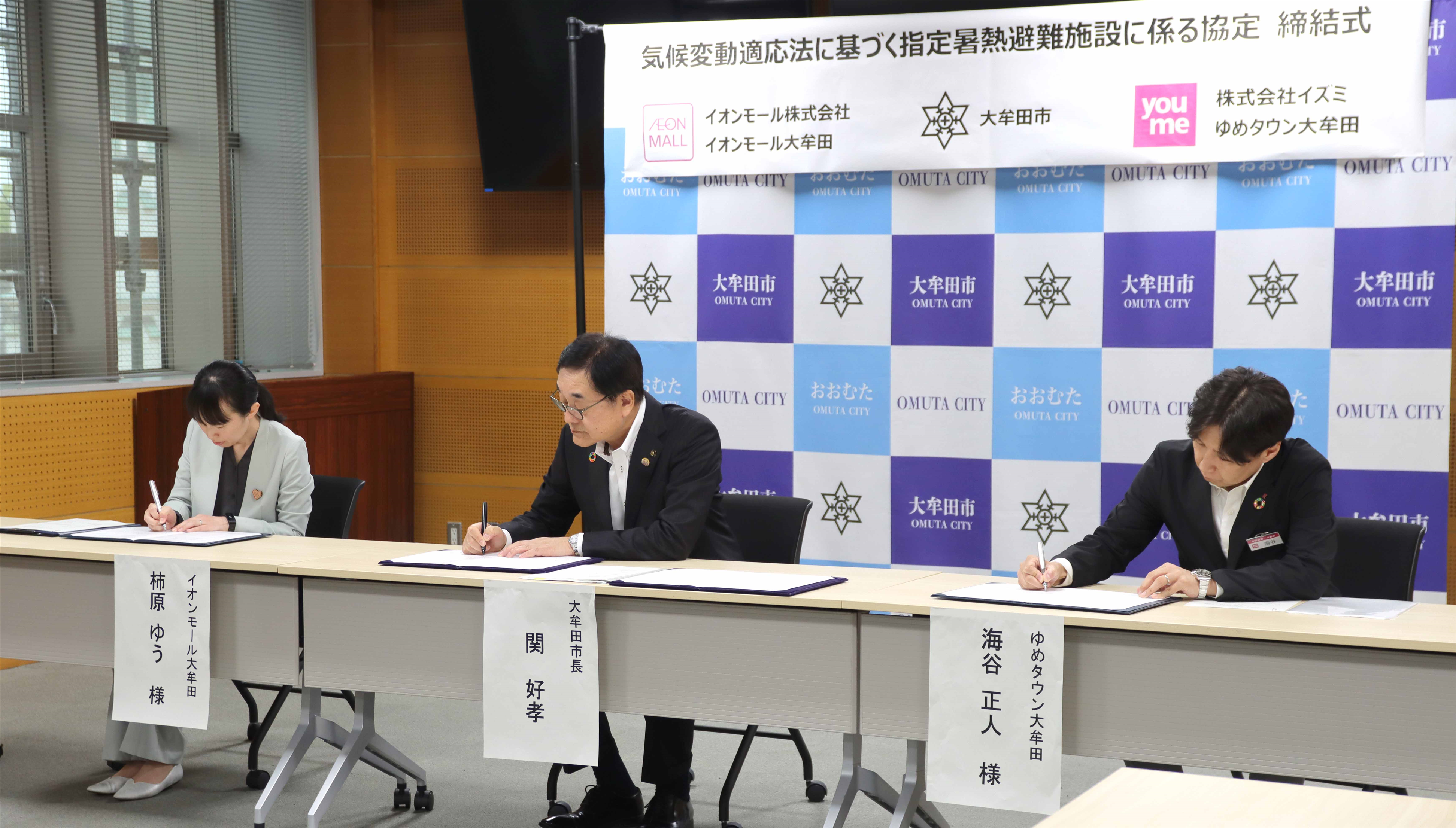 協定書にサインする様子