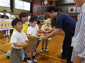 応援のプレゼントをご家族に渡す園児