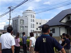 建物の外観を眺める教員