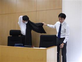 法服を羽織らせてもらう生徒