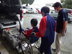 福祉車両の操作をしながら車椅子を移動させる生徒