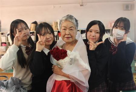 赤いドレスを着用するシニアモデルと高校生