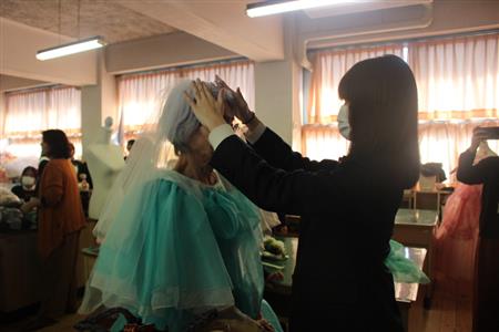 ベールをつけるシニアモデルと高校生