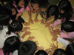 子どもたちが手で円をつくっている写真
