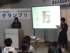 糸電話の実験を発表する橘中学校2年の松藤さんと西河さん 糸電話の実験を発表する橘中学校2年の松藤さんと西河さん