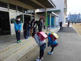 昇降口で下級生に挨拶する大牟田中央小の6年生