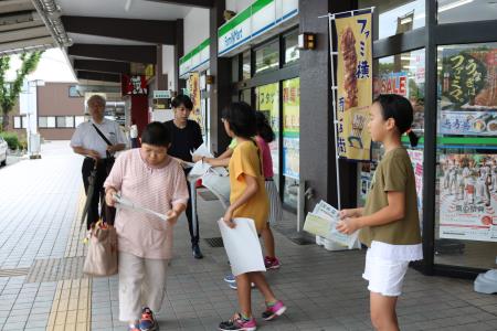 大牟田駅前で手作り新聞を配布する大正小児童